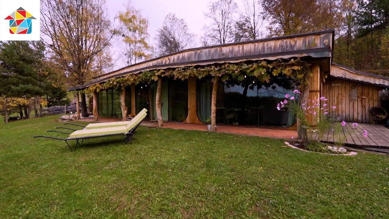 Z zeleno streho pokrita gorička hiška, v kateri biva tudi miška